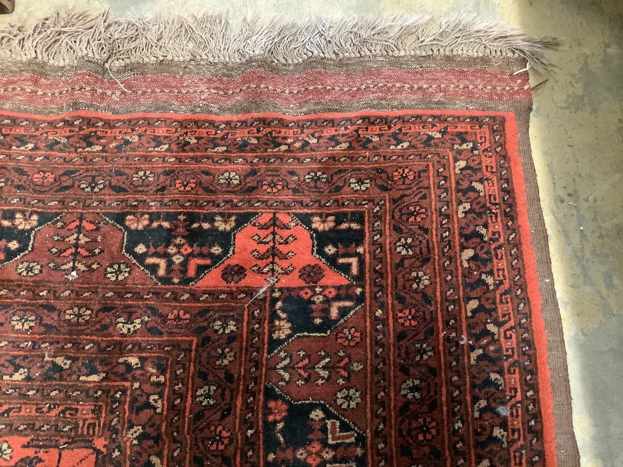 An Afghan red ground carpet, 360 x 260cm